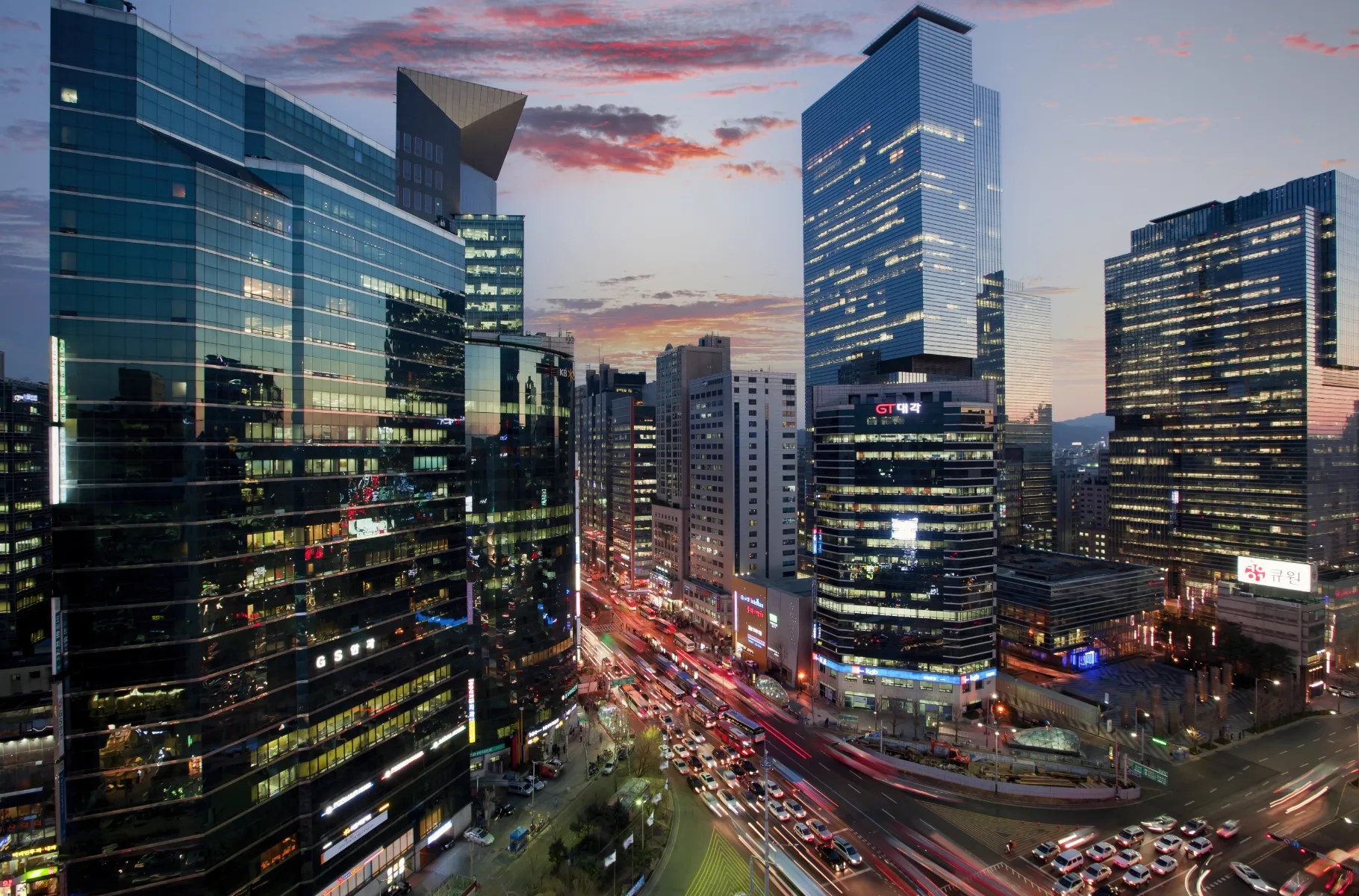 Gangnam Station intersection at dusk with the GS Eye Center building among the towers