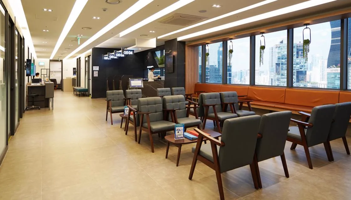 Second waiting lounge with armchairs and floor-to-ceiling city views