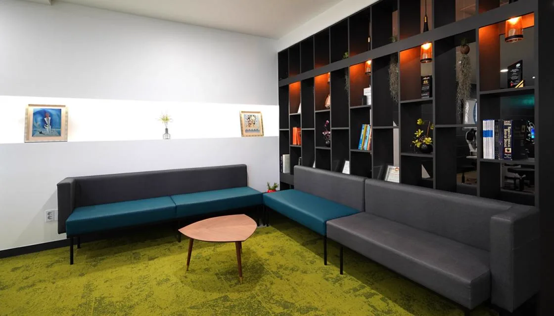 Treatment waiting area with bench seating and a display bookshelf