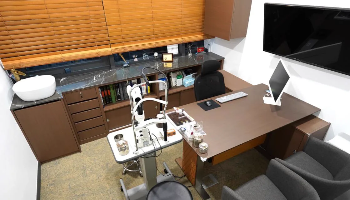 Doctor's office with slit lamp microscope beside the consultation desk
