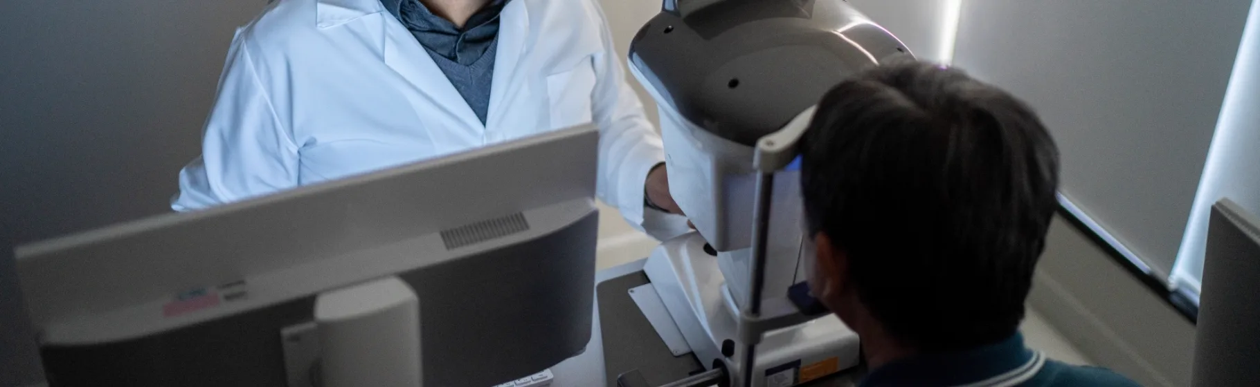 Ophthalmologist examining a patient with a diagnostic device at GS Eye Center