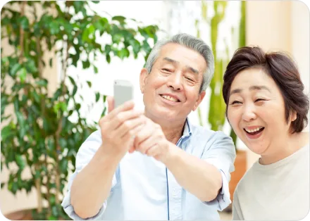 Senior couple smiling while looking at a smartphone together