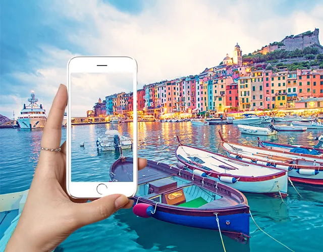 Hand holding a phone photographing a harbor - near, intermediate and far scenes in one view
