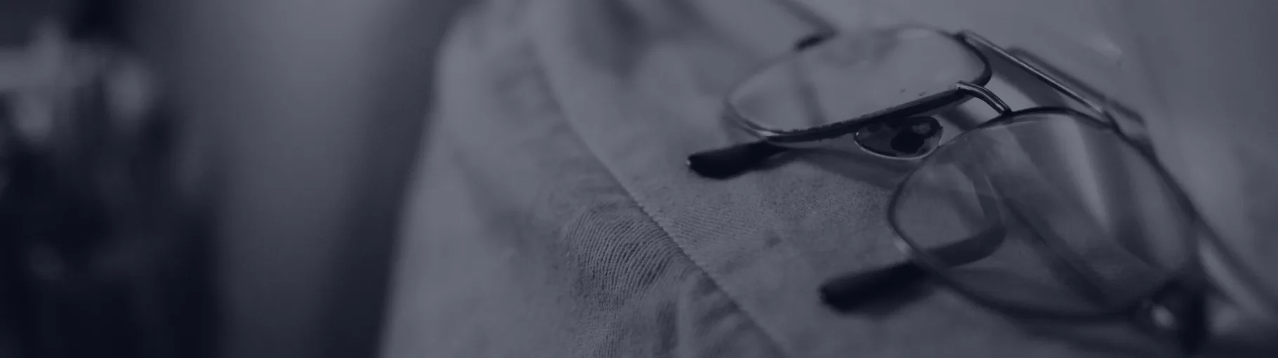 Eyeglasses resting folded on a shoulder, no longer needed